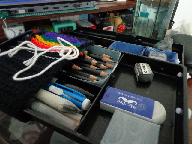 erasers and pencils in a stepped plastic tool box